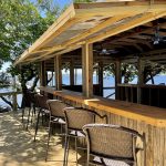 Exterior shot of boathouse with chairs lined up along the bar.